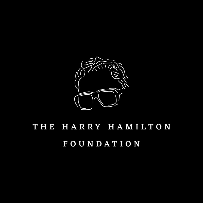 Harry Hamilton Foundation logo in white on a black background. The logo features a line illustration of the top of Harry's head down to his glasses, with the type below in serif typeface.