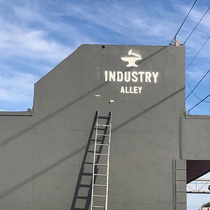 Photo of Industry Alley side wall with ladder with logo